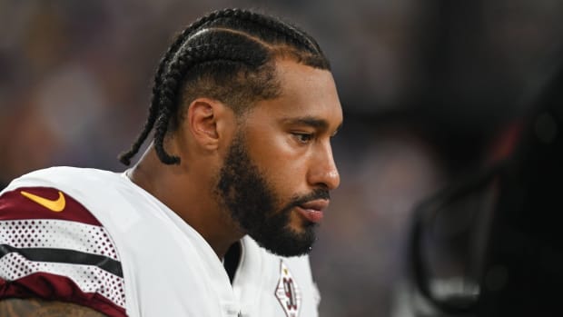 Commanders pass rusher Montez Sweat looks on without a helmet during a game.